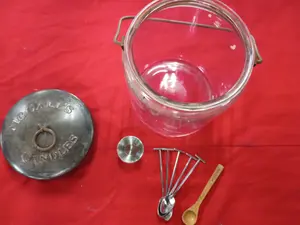 A Collection of McCall's Candles Glass Jar and Stainless Steel Tools
