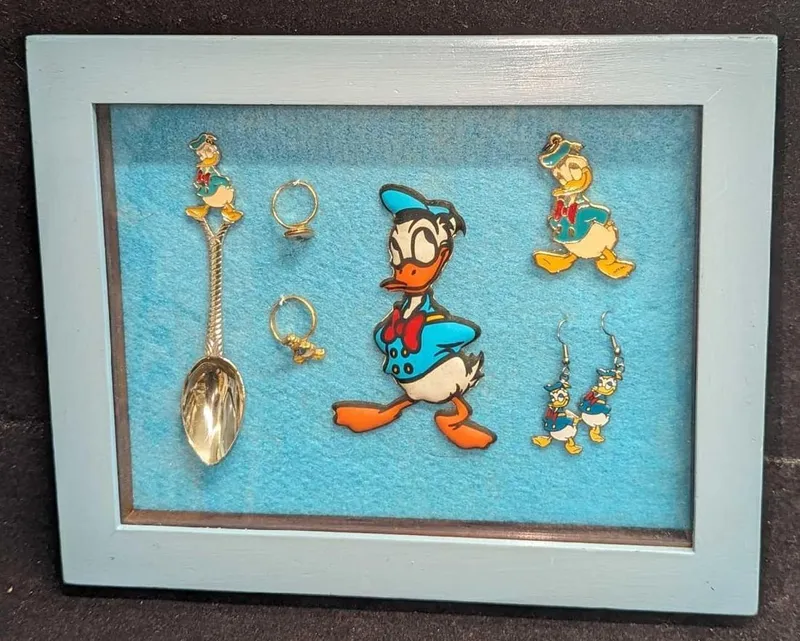 A Lot of 6 Vintage Donald Duck Framed Collectibles Earrings Rings Spoon Charm Pendant Figure from auction in Orlando, Florida — image 14
