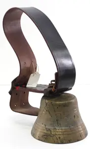 Brass cowbell on wide leather strap