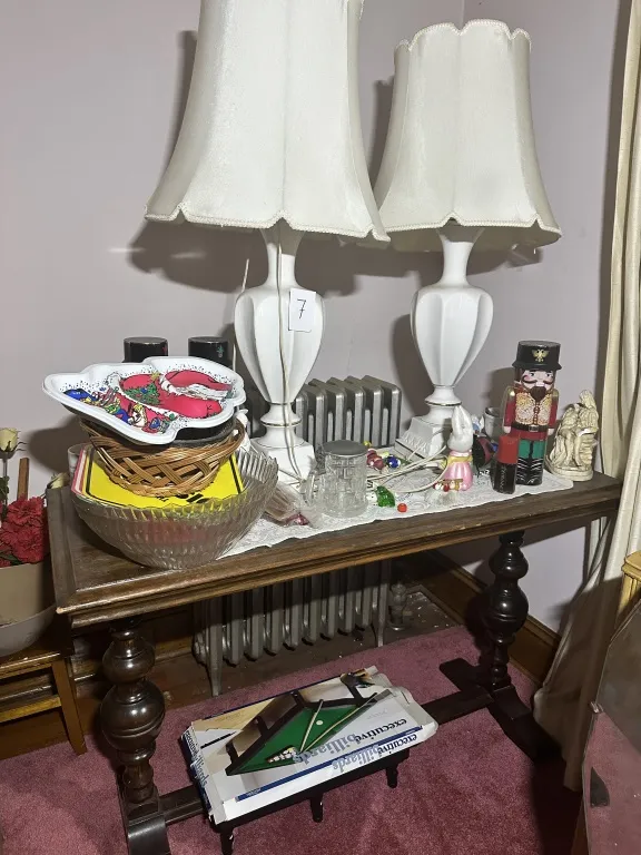 Table With Lamps & Contents wood table with turned legs, pair of white table lamps, glass bowl, basket, holiday plate, nutcracker, small figurines, and assorted contents as shown from auction in Clifford , Pennsylvania — image 4