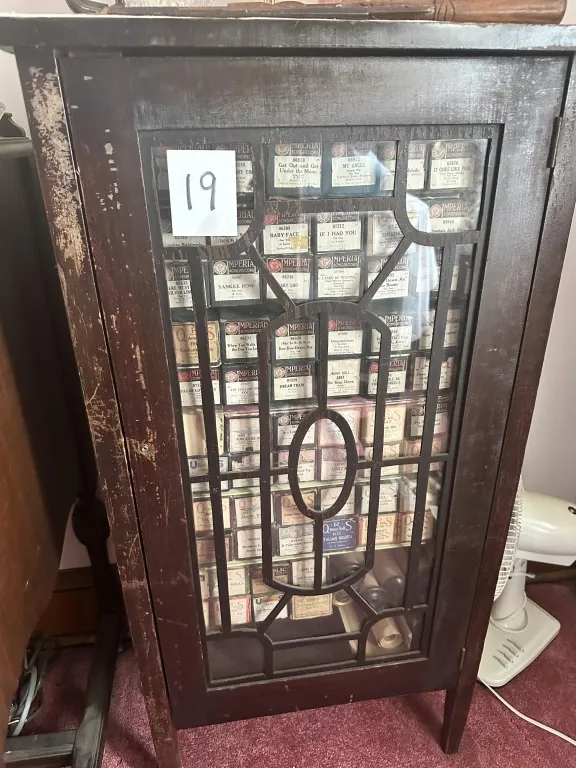 Cabinet With Player Piano Rolls wood cabinet with glass door and assorted player piano rolls. from auction in Clifford , Pennsylvania — image 16