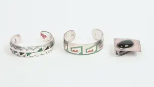 TWO NAVAJO CUFF BRACELETS AND A PENDANT.