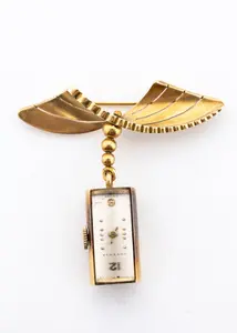 AN 18K GOLD BROOCHE WITH A DECO WATCH.
