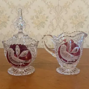 A Pair of Ruby Stained Cut Crystal Bird Motif Sugar Bowl and Creamer