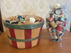 A Large Collection of Vintage Sewing Notions and Thread Spools with Slat Basket and Glass Vase
