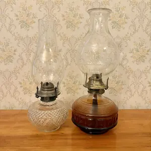 Two Glass Oil Lamps Including One Amber Pressed Glass and One Clear Patterned Glass