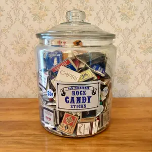 A Collection of Vintage Advertising Matchbooks and Matchboxes in a Glass Rock Candy Apothecary Jar