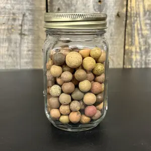 A Collection of Antique Earthenware Game Marbles in a Modern Glass Jar