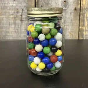 A Collection of Assorted Machine-Made Opaque Glass Marbles in a Glass Mason Jar